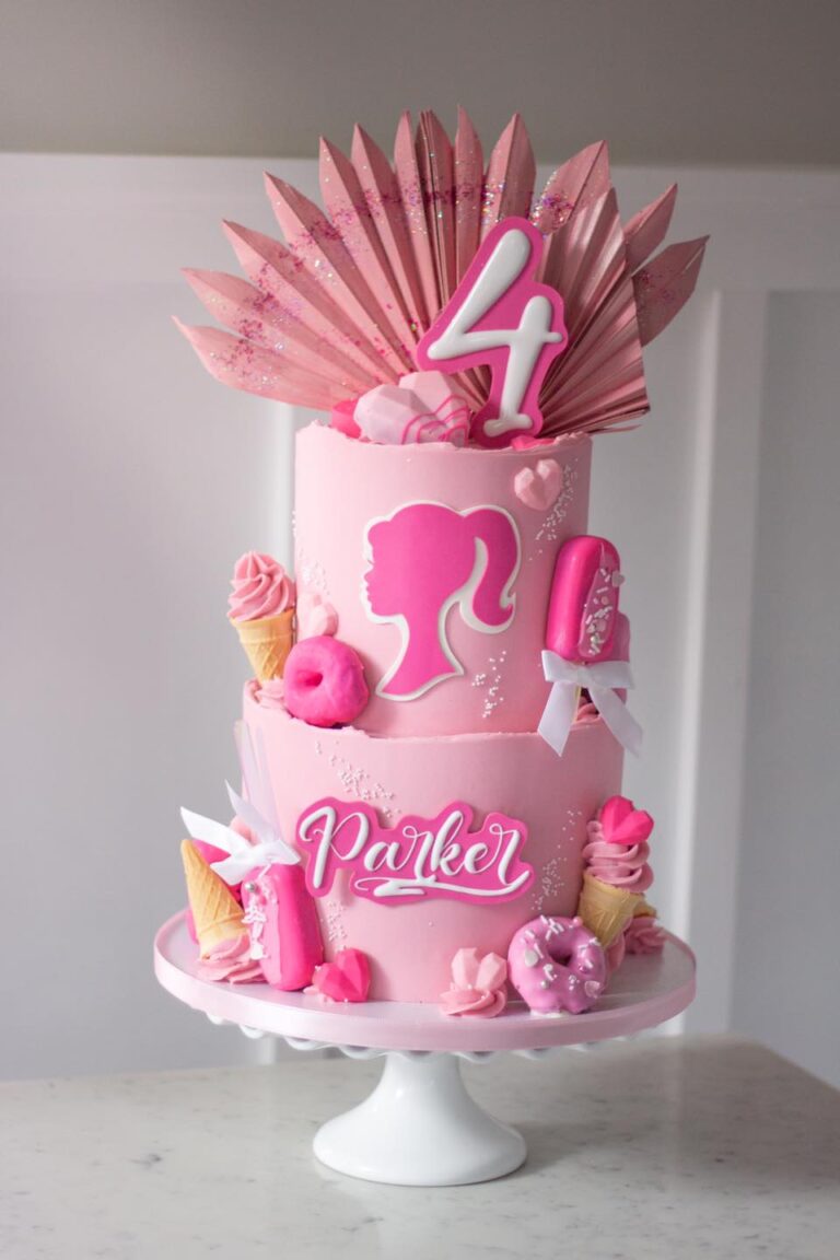 Parker's Pink 4th Birthday Cake: A whimsical celebration featuring a 2-tier cake in sizes 8"-6", adorned with buttercream icing. The cake is playfully decorated with handmade treats such as cakecicles, donuts, and ice creams, creating a fun and delightful design for Parker's 4th birthday celebration